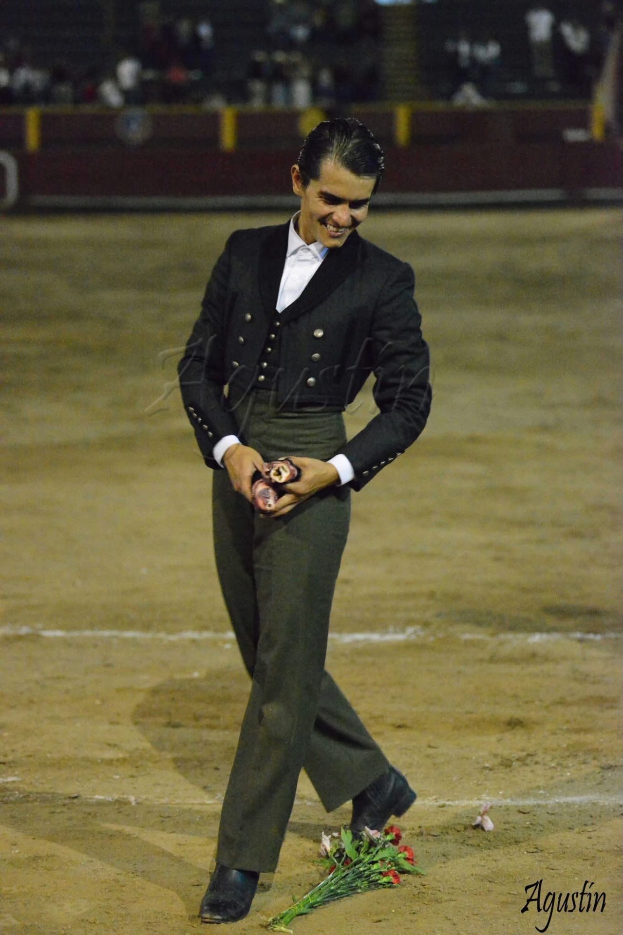 Torero sonriente con los trofeos en la mano tras la faena